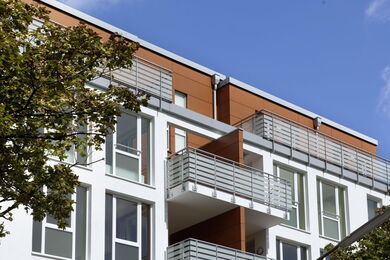 Brown and white façade with floor-to-ceiling windows and grey balconies