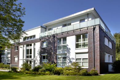 Modern residential building with large windows and dark clinker bricks in Bandkampsweg