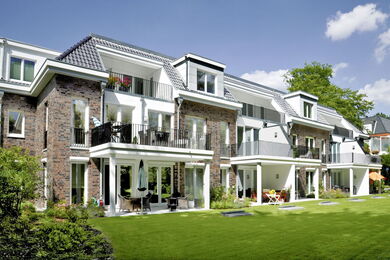 Apartment block with clinker brick façade and large balconies/terraces and spacious lawn area